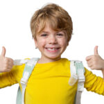 Smiling boy in yellow shirt with backpack over his shoulders gives two thumb's up.
