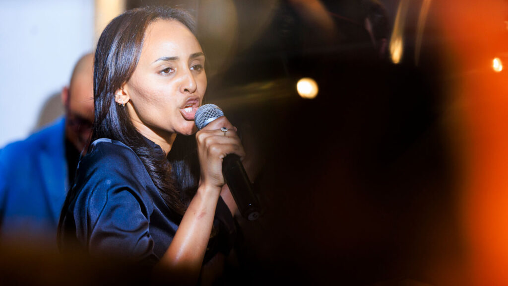 Melat Kiros yells into a microphone during her victory party.