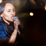 Melat Kiros yells into a microphone during her victory party.