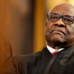 Close-up of Clarence Thomas in judicial robes leaning back.