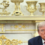 President Trump in the Oval Office in front of gold-plated mantle.