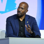Van Jones in a blue jacket speaks at a podium.