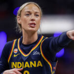 Indiana Fever star Sophie Cunningham in a blue uniform with gold trim points.