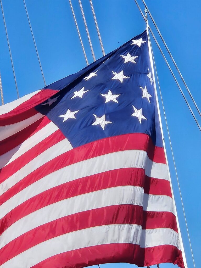 Tall Ships Bring the Spirit of ‘76 to Virginia 1 Low angle shot of an American flag with 15-stars against a blue sky.