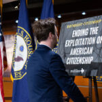 A congressional staffer sets up a posted on stage for Rep. Brian Babin's news conference on the Birthright Citizenship Act in the U.S. .Capitol on Thursday, January 23, 2025.