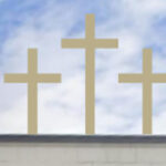 Three golden crosses stand on top of a building.