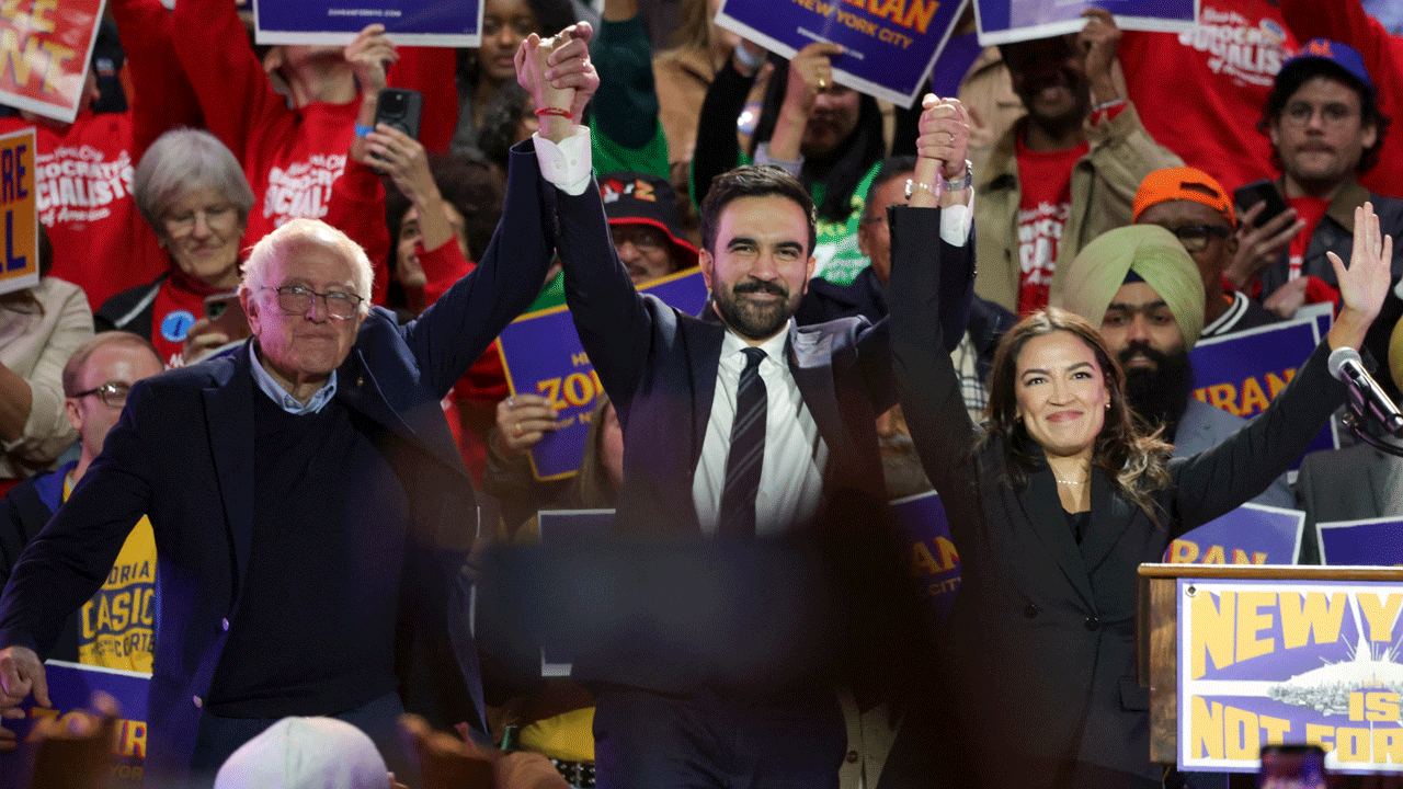 New York City mayoral candidate Zohran Mamdani (C) holds hands with US Senator Bernie Sanders (I-VT) (L) and US Representative Alexandria Ocasio-Cortez (D-NY) at the end of a campaign rally at Forest Hills Stadium in the Queens borough of New York City on October 26, 2025. New Yorkers will cast their votes for mayor on November 4, 2025. Mamdani, the Democratic candidate, is the current frontrunner ahead of former New York Governor and independent candidate Andrew Cuomo and Republican candidate Curtis Sliwa. (Photo by ANGELA WEISS / AFP) (Photo by ANGELA WEISS/AFP via Getty Images)