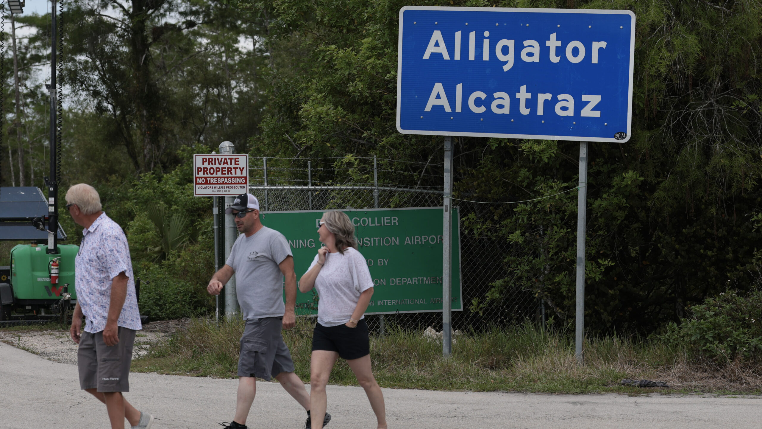 OCHOPEE, FLORIDA - APRIL 22: People walk near the front entrance to the immigration detention center in the Florida Everglades known as “Alligator Alcatraz" on April 22, 2026, in Ochopee, Florida. A federal appeals court overturned an injunction by a district court judge requiring officials to dismantle “Alligator Alcatraz” in response to a lawsuit filed by environmental groups. (Photo by Joe Raedle/Getty Images)