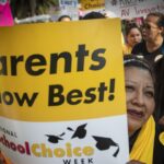 A woman holding a sign that says "Parents know best! School Choice Week"