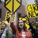 Protesters holding "green new deal" signs