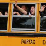 Students waving from a bus that says "Fairfax County"