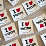 A table full of stickers to hand out to voters is shown.