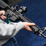 An attendee holds a Springfield Armory SAINT AR-15 style rifle.