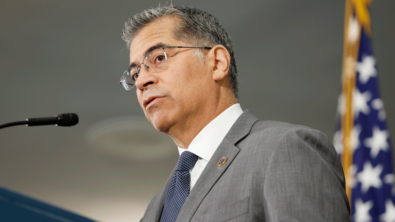 Xavier Becerra stands at a podium.