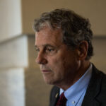 Then Sen. Sherrod Brown, D-Ohio, looks off to the side.