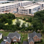 In an aerial view, an Amazon Web Services data center is shown situated near single-family homes on July 17, 2024 in Stone Ridge, Virginia.