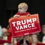 A baby holding a Trump Vance sign