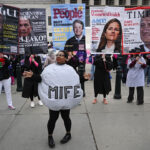 A woman in a "Mife" costume dances around while abortion activists stand behind her with signs at the U.S. Supreme Court.