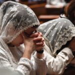 Two girls and one woman, all praying