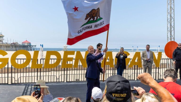 Steve Hilton waves the California State flag.