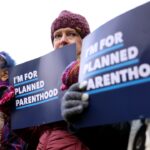 Protesters holding Planned Parenthood signs