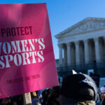 A protester holds a pink sign reading Protect Womens Sports in front of the U.S. Supreme Court.