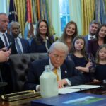 President Donald Trump signs a document during an event with dairy farmers
