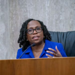 Justice Kentanji Brown Jackson gestures as she sits at a dais.