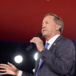 Texas Attorney General Ken Paxton speaking into a microphone