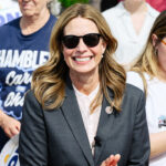 Dr. Amy Acton, Democratic nominee for Ohio's governor, smiles at outdoor an event while she wears sunglasses and a dark suit.