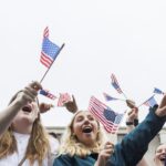 Parade attendees holding American Flags