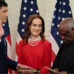 Kevin Warsh with his hand on a book with his wife Jane Lauder, and U.S. Supreme Court Associate Justice Clarence Thomas