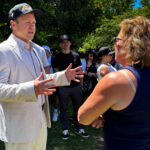 Spencer Pratt in a white jacket speaks to a voter.