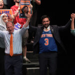 Claire Valdez, Brad Lander, Mayor Zohran Mamdani, and Darializa Avila Chevalier raise their hands on stage during a rally.