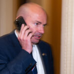 Sen. Mike Lee speaks on his phone.