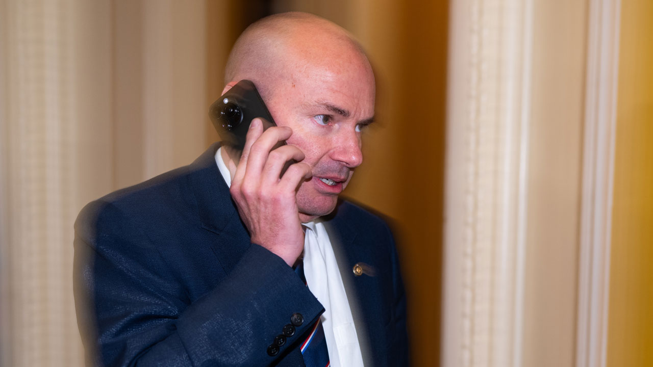Sen. Mike Lee speaks on his phone.