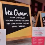 Signs advertise ice cream at a food festival.