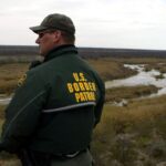 Border Patrol agent looks out at a vista