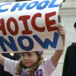 Girl holding a sign that says "school choice now"