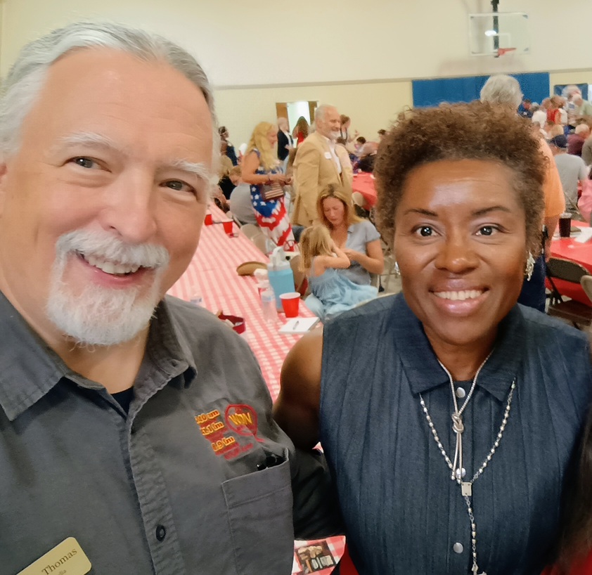 Winsome Earle-Sears poses with Joe Thomas at a GOP picnic inside a gymnasium. 