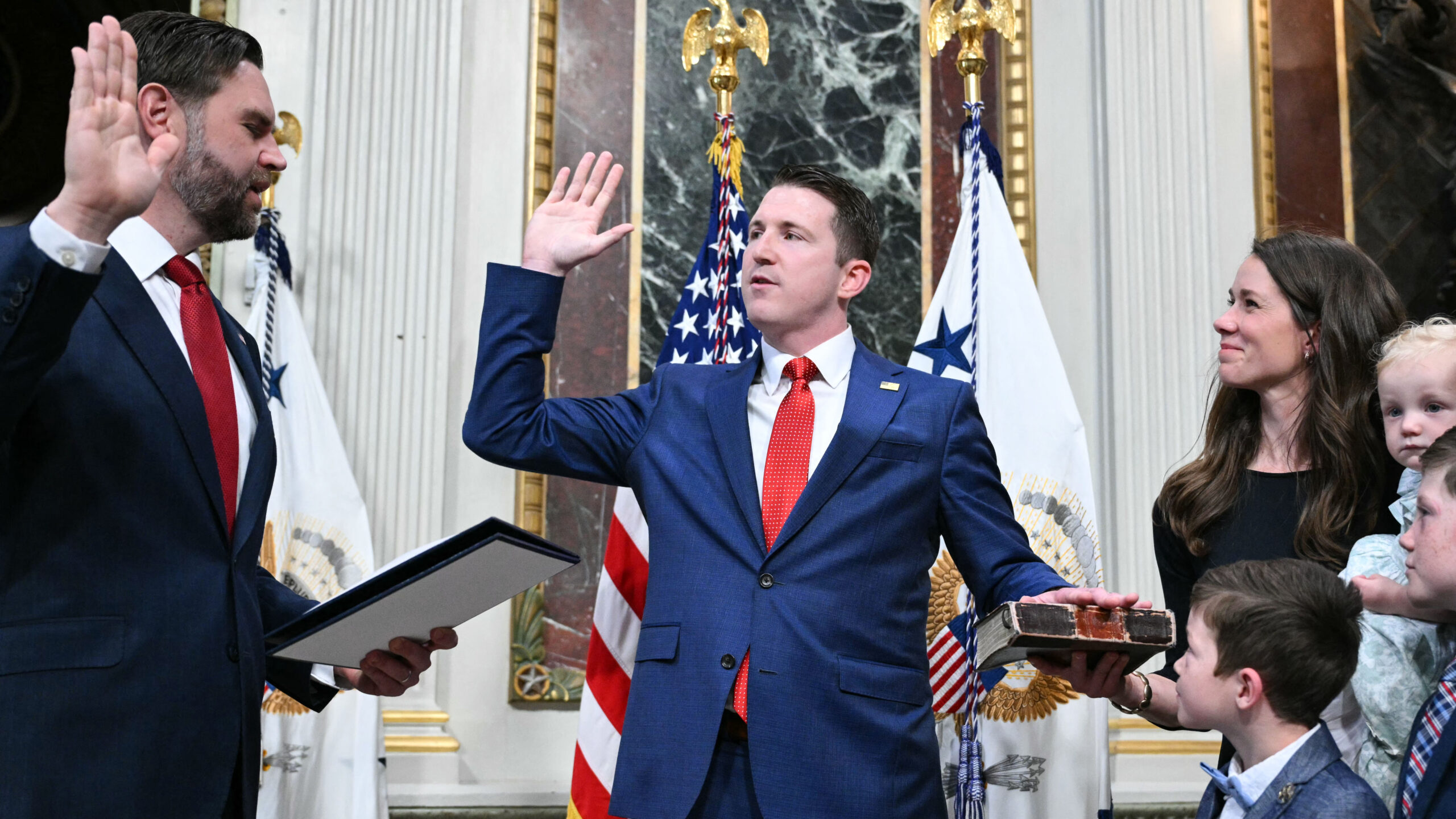 (L/R) US Vice President JD Vance swears in Colin McDonald as Assistant Attorney General for the National Fraud Enforcement Division as McDonald's wife Janessa holds the Bible in the Eisenhower Executive Office Building, next to the White House in Washington, DC on April 1, 2026. McDonald will be the first Assistant Attorney General for the Department of Justice's newly created National Fraud Enforcement Division. (Photo by Mandel NGAN / AFP via Getty Images)