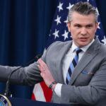 Secretary of War Pete Hegseth speaks to reporters in the Pentagon.