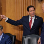 Marco Rubio is greeted by U.S. Sen. Rick Scott (R-FL) (R) as he arrives to testify during a Senate Foreign Relations Committee.