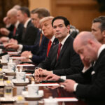 Secretary of State Marco Rubio looks on next to U.S. President Donald Trump.