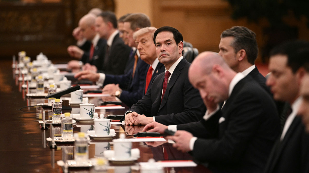Secretary of State Marco Rubio looks on next to U.S. President Donald Trump.