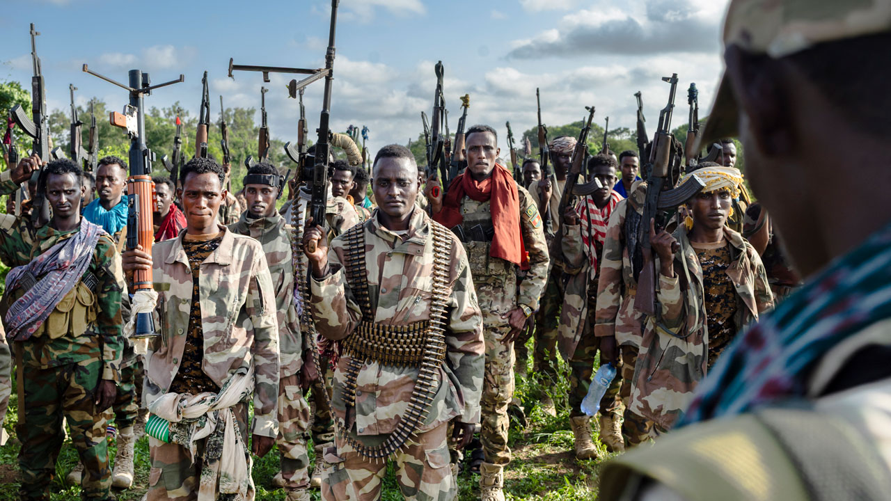 Home 4 Soldiers of the Somalia National Army (SNA) raise their weapons when they gathered near their camp for a talk from visiting senior officers at Awdheegle, one of several towns recently liberated from the Al-Qaeda-linked militants, Al-Shabaab.