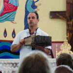 Shadi Khalloul presents an ancient Aramean Bible while speaking to a group of students at the Syriac Maronite Church of Antioch in Jish.