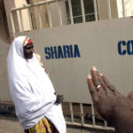 Safiya Husseini, in company of her brother Sanni, arrives at the Sokoto State Sharia Court of Appeal, 18 March, 2002 to appeal against the judgement of an Islamic court which sentenced her to death by stoning.