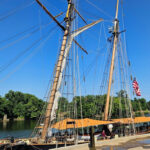 Three tall ships along a dock.
