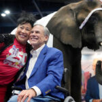 Aida Scott takes a photo with Governor Greg Abbott in front of an elephant named, Paige.